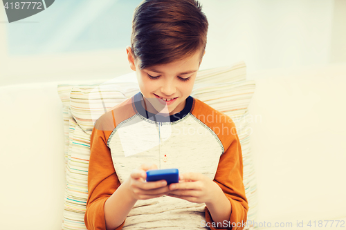 Image of boy with smartphone texting or playing at home