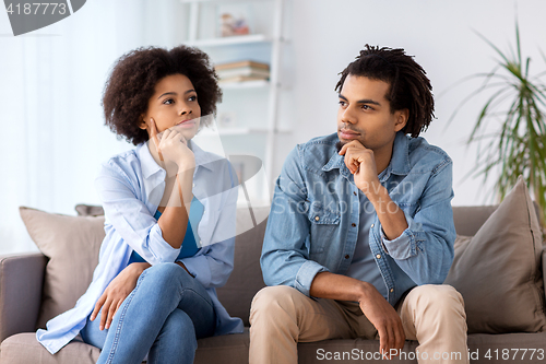 Image of happy couple sitting on sofa at home