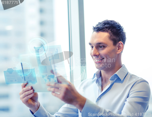 Image of smiling businessman with tablet pc in office