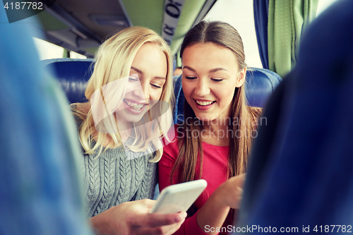 Image of happy young women in travel bus with smartphone