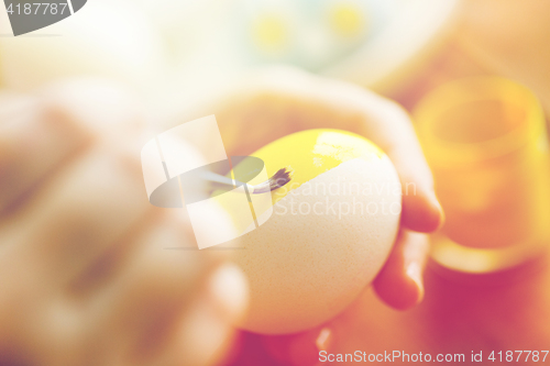 Image of close up of woman hands coloring easter eggs