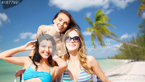 Image of happy young women in bikinis on summer beach