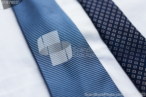 Image of close up of shirt and blue patterned ties