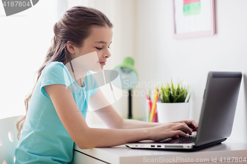 Image of girl typing on laptop at home