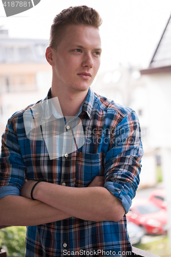 Image of man standing at balcony