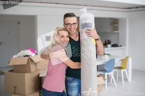 Image of couple carrying a carpet moving in to new home