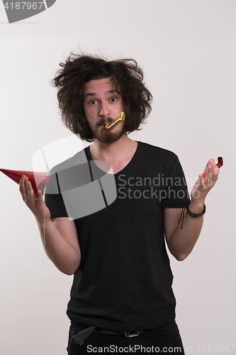 Image of Portrait of a man in party hat blowing in whistle