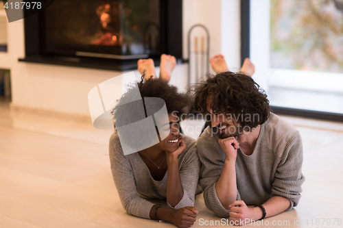 Image of multiethnic couple used tablet computer on the floor