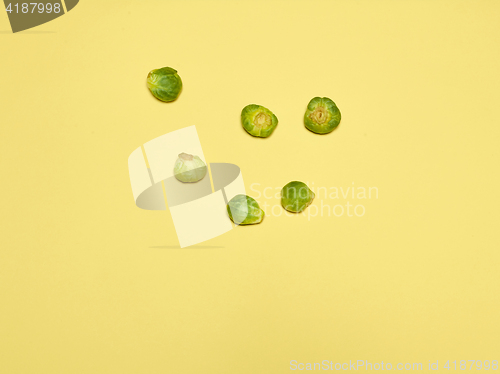 Image of The piles of Brussels sprouts on a yellow background