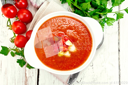 Image of Soup tomato in white bowl with vegetables on board top