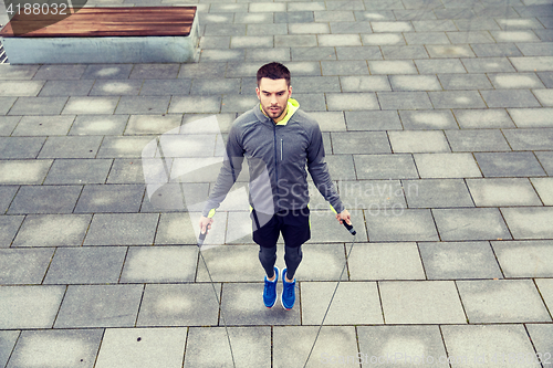 Image of man exercising with jump-rope outdoors