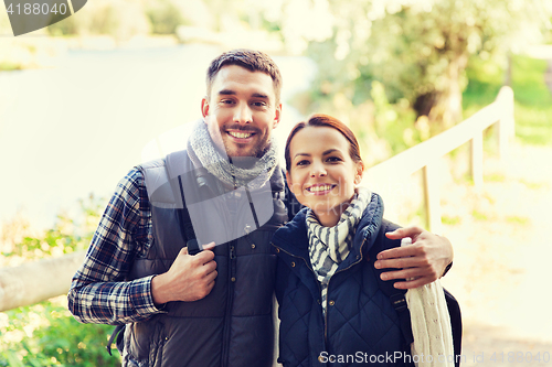 Image of happy couple with backpacks hiking and hugging