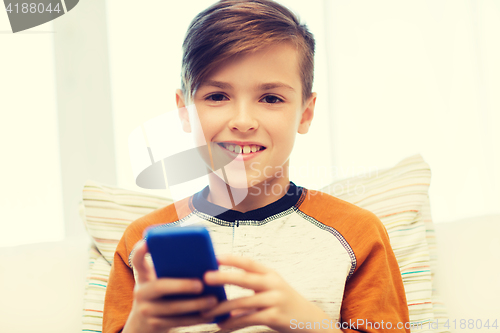 Image of boy with smartphone texting or playing at home