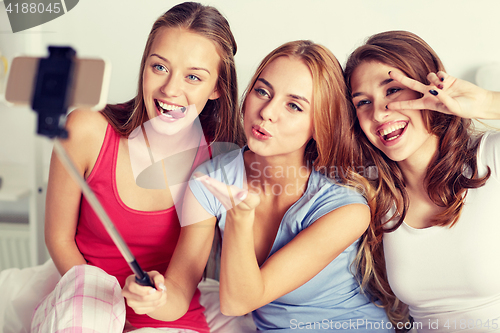 Image of teen girls with smartphone taking selfie at home