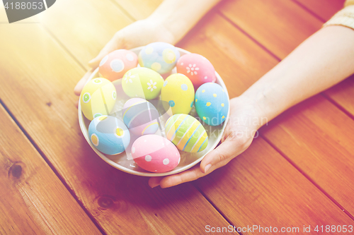 Image of close up of woman hands with colored easter eggs