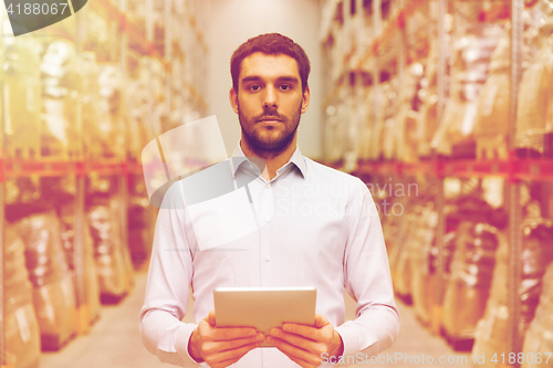 Image of businessman with tablet pc at warehouse