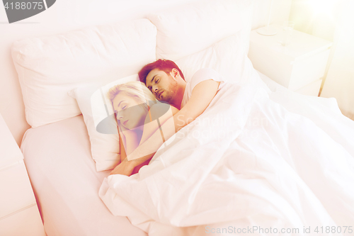 Image of happy couple sleeping in bed at home