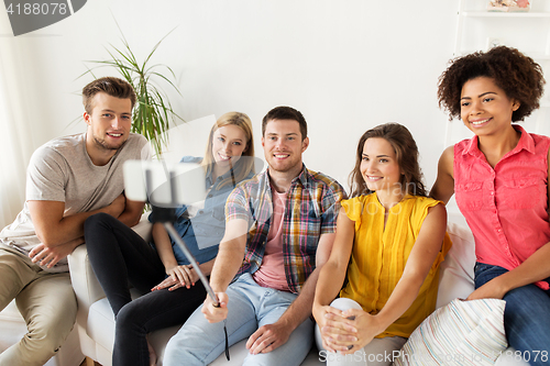 Image of happy friends taking selfie by smartphone at home