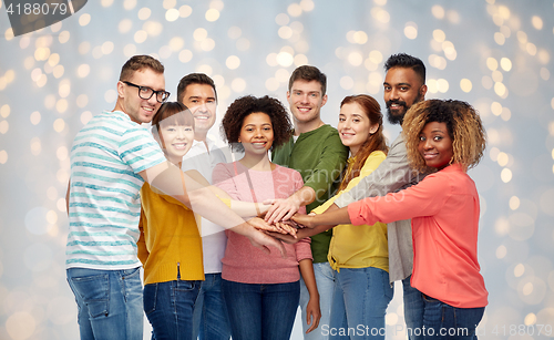 Image of international group of happy people holding hands