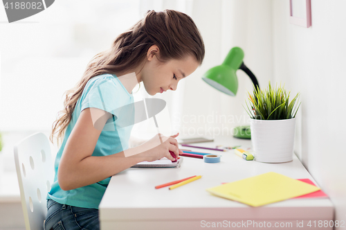 Image of happy girl drawing at home