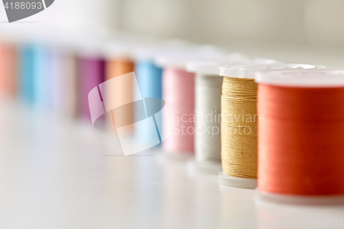 Image of row of colorful thread spools on table