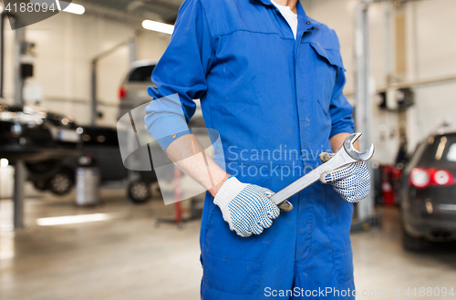 Image of auto mechanic or smith with wrench at car workshop