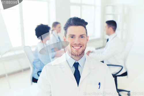 Image of happy doctor over group of medics at hospital