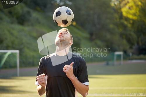 Image of soccer player playing with ball on field