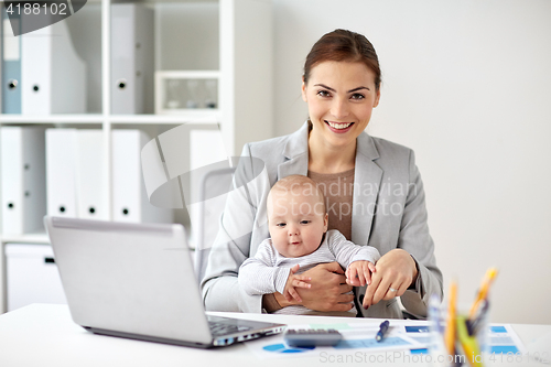 Image of happy businesswoman with baby and laptop at office