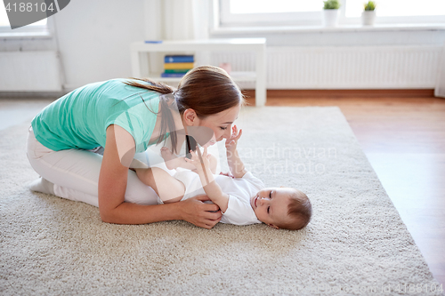 Image of happy mother playing with baby at home