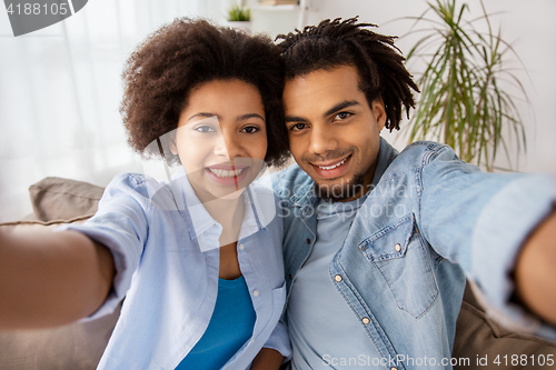 Image of happy couple taking selfie at home