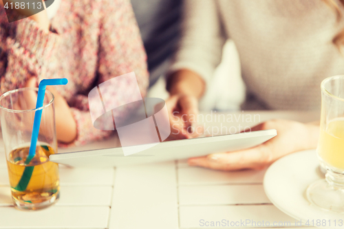 Image of close up of family with tablet pc at restaurant