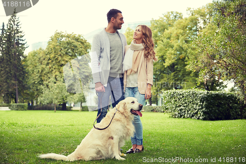 Image of happy couple with labrador dog walking in city