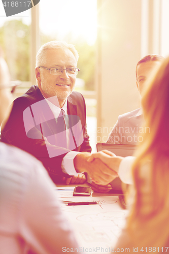 Image of senior businessman making handshake at office