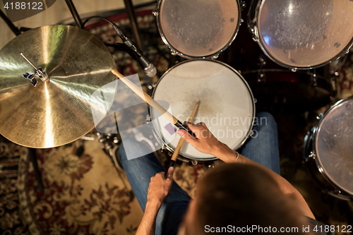 Image of male musician playing drums and cymbals at concert