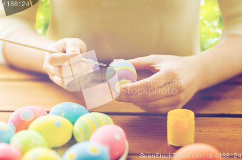 Image of close up of woman hands coloring easter eggs