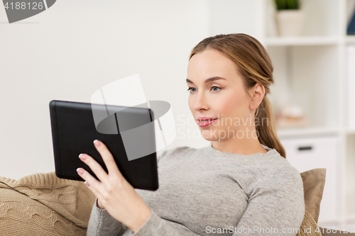 Image of smiling woman with tablet pc at home