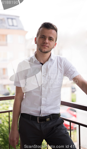 Image of man standing at balcony