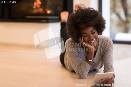 Image of black women used tablet computer on the floor