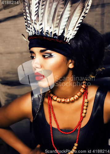 Image of young pretty woman with make up like red indian, futher in hair,