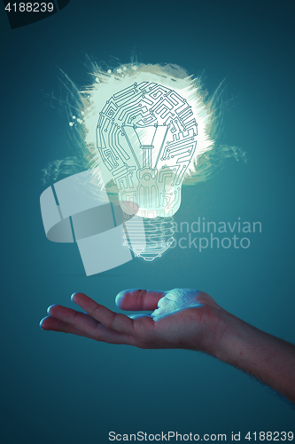 Image of Hands of business person holding illuminated light bulb sign