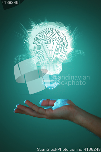 Image of Hands of business person holding illuminated light bulb sign