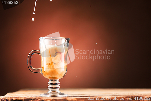 Image of Adding milk to a cup of coffee.