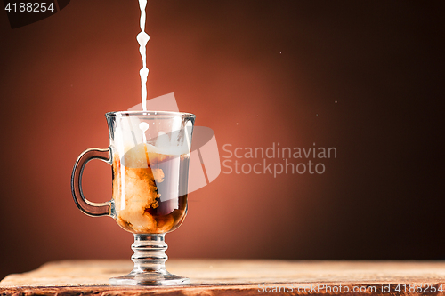 Image of Adding milk to a cup of coffee.