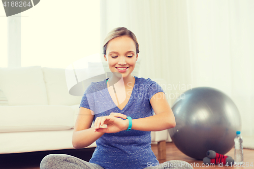 Image of happy woman with heart-rate watch exercising