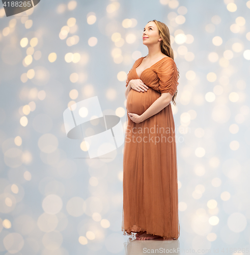 Image of happy pregnant woman touching her big belly