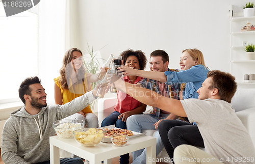 Image of friends having party and clinking drinks at home