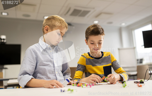 Image of happy children building robots at robotics school