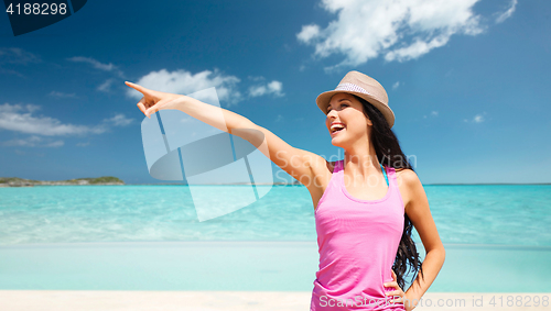 Image of happy young woman in hat on summer beach