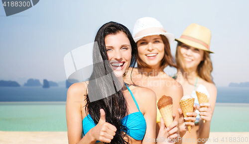 Image of group of happy young women with ice cream on beach